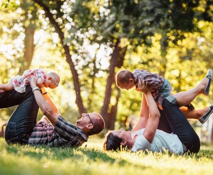 A joyful family enjoying playtime in a sunny park, capturing moments of laughter and happiness.