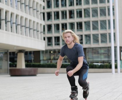 Young man roller skating through urban landscape, enjoying a dynamic outdoor lifestyle.