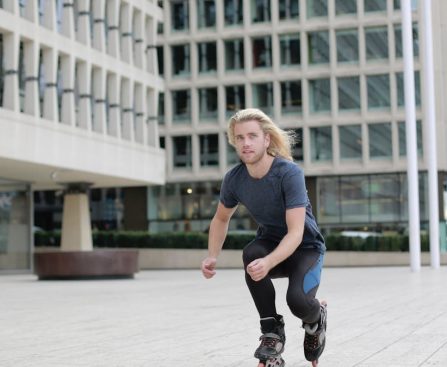 Young man roller skating through urban landscape, enjoying a dynamic outdoor lifestyle.